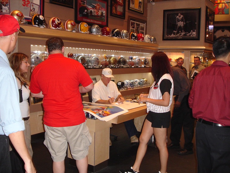 Photo of Pete Rose signing autographs during an in store appearance.