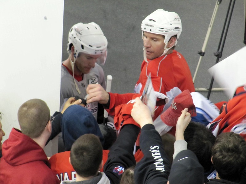 Photo of Washington Capitals players signing autographs during training camp.